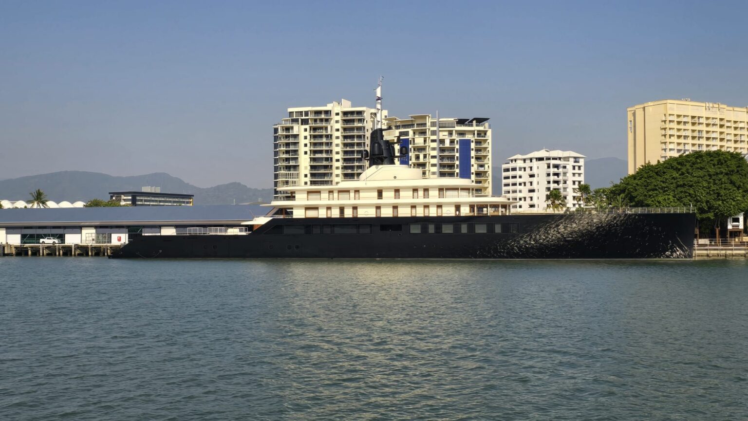 Large superyacht berthed in Cairns with the city behind