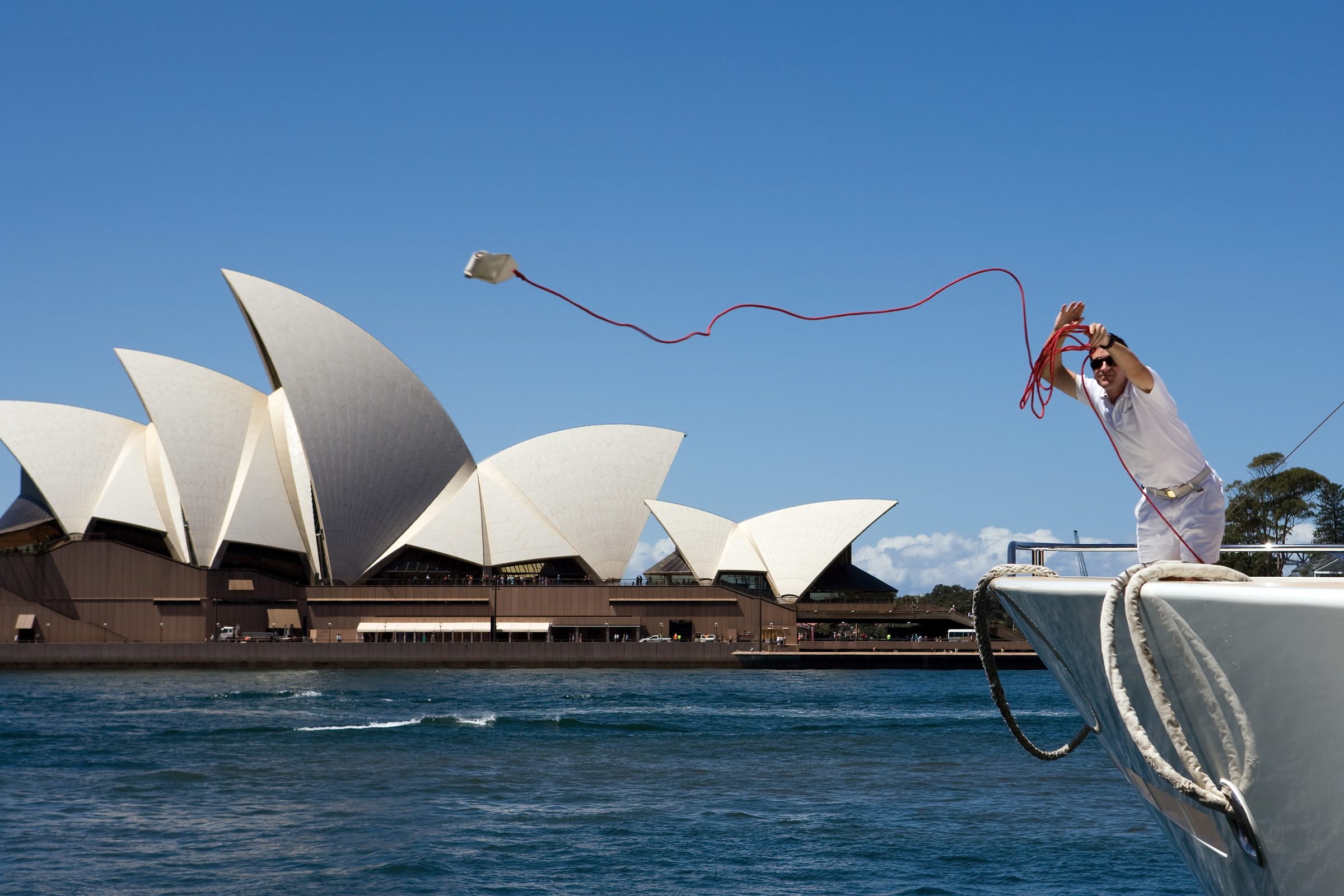 Crew throwing a heaving line beside the Sydney Opera House