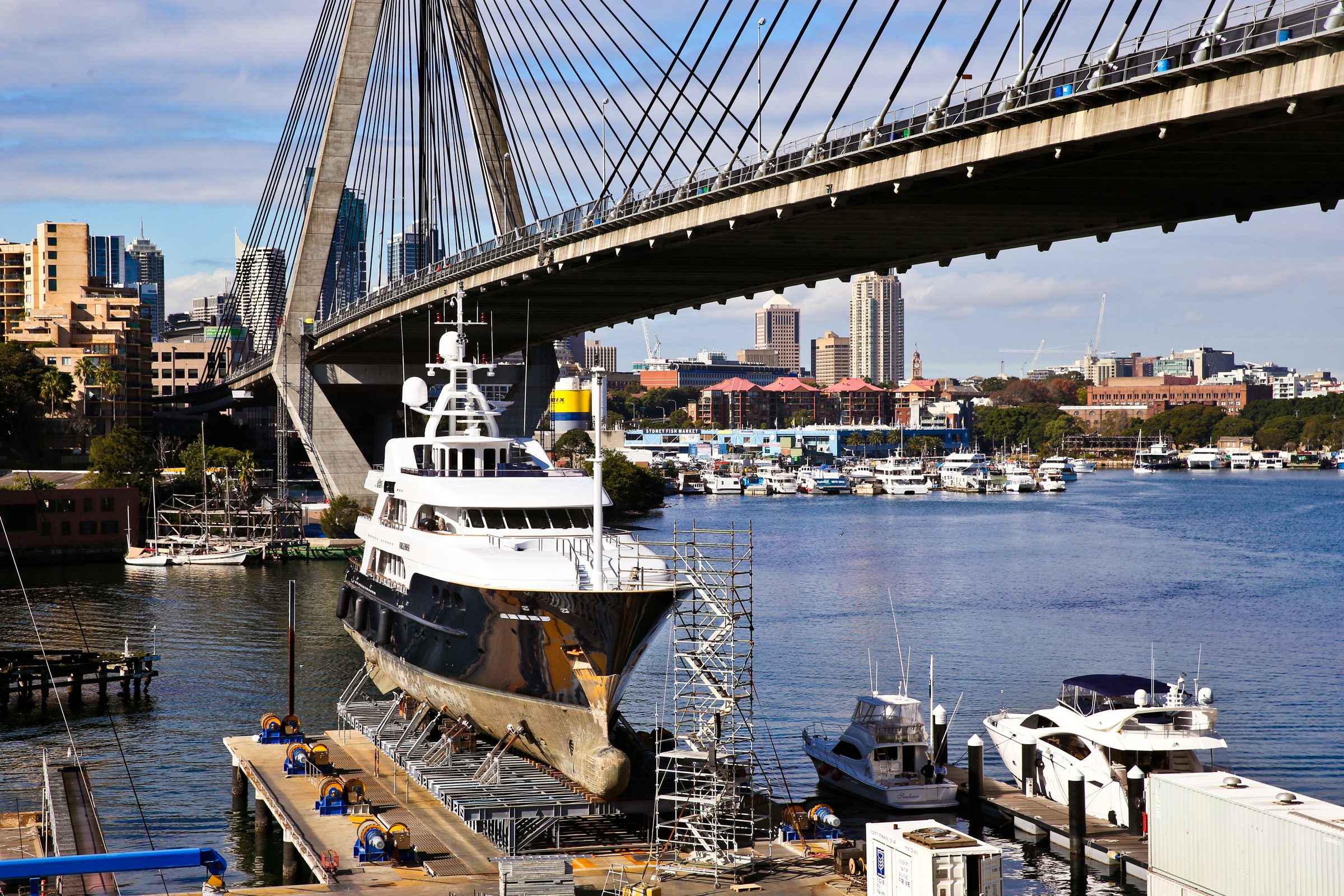 Superyacht in refit at a Sydney shipyard beneath the Anzac Bridge